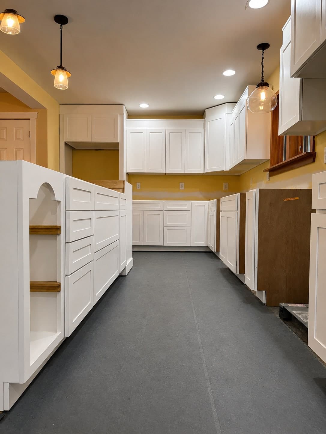 White shaker kitchen cabinetry finished and rehung, floor still under protection