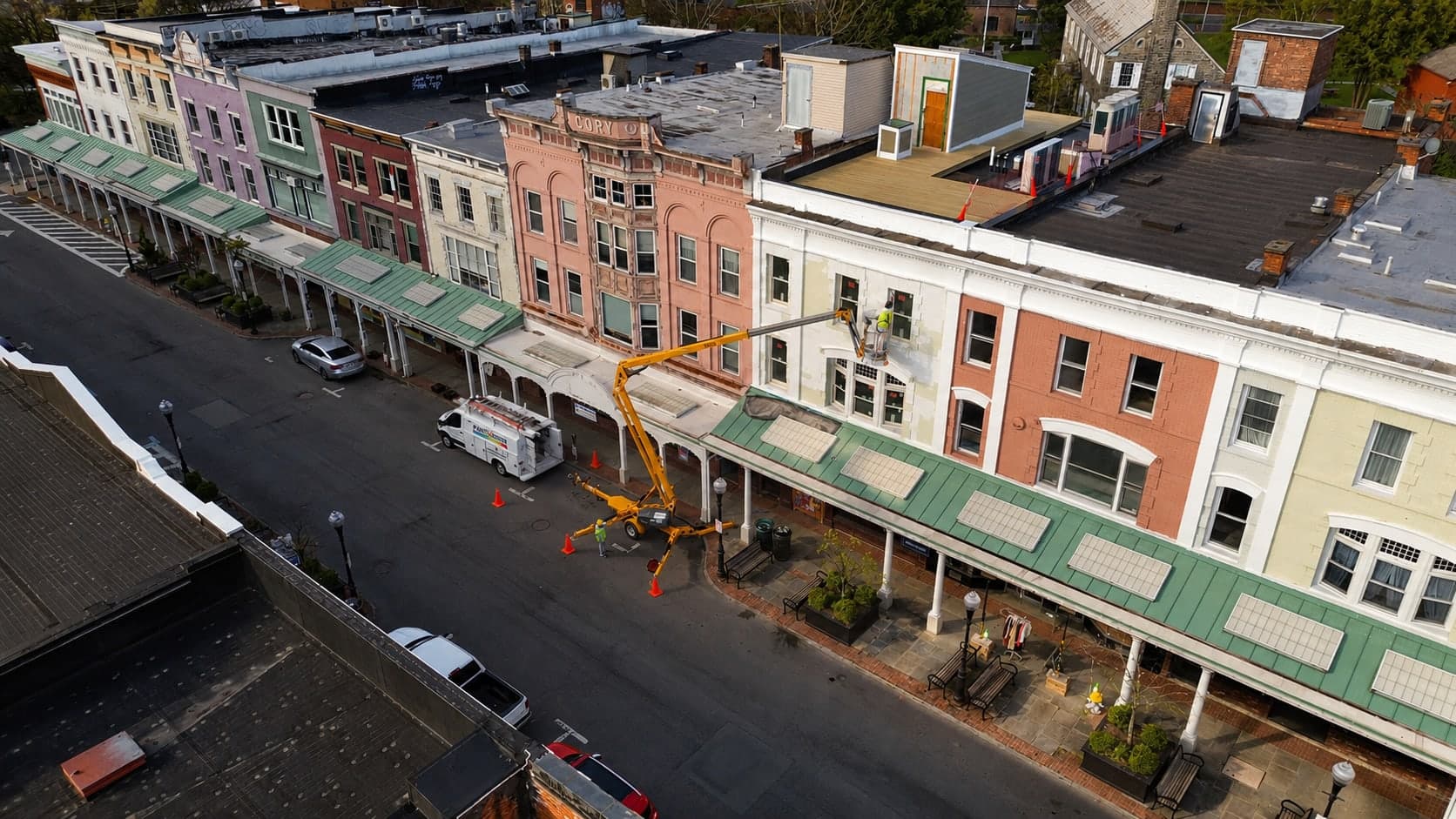 Boom lift working a historic Main Street facade above the storefronts, seen from above