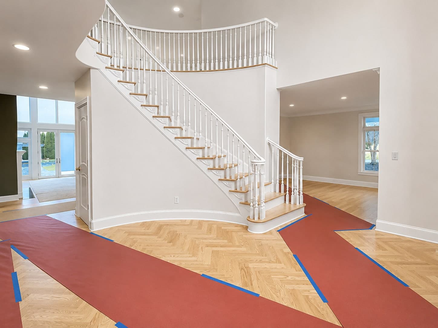 Curved staircase and herringbone floor fully protected ahead of an interior repaint