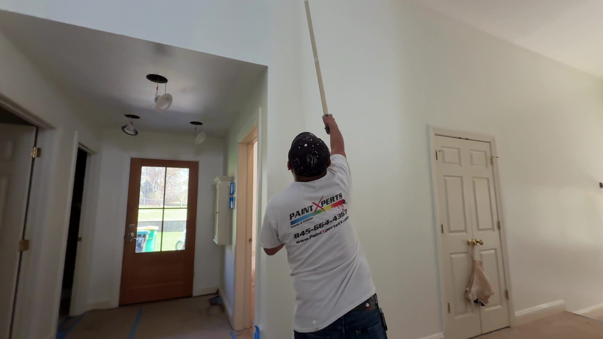 A PaintXperts painter rolling a ceiling with an extension pole on an interior job in the Hudson Valley